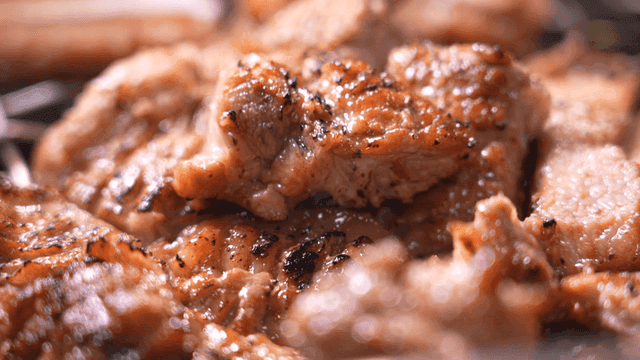 Seasoned pork ribs grilled with tongs