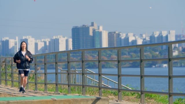 Woman jogging along a riverside path