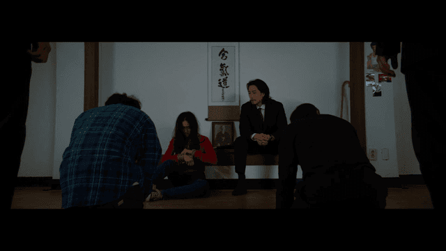 일본식 전통방에 묶여 있는 여자와 무릎 꿇고 있는 남자들