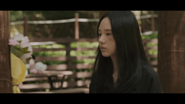 생각에 잠긴 채 길을 걷는 얼굴에 상처가 난 여성