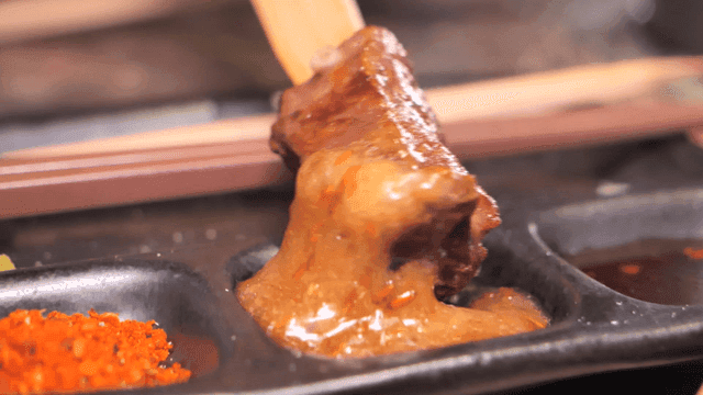 Grilled meat skewers dipped in sauce