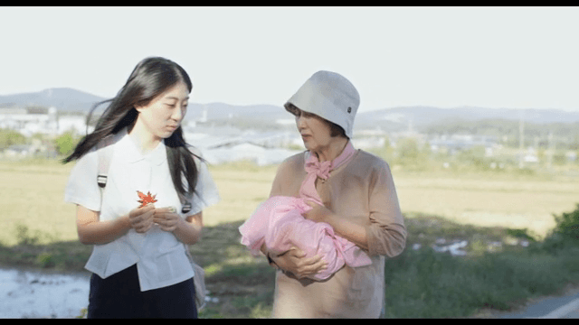 Elderly woman and girl walking along a country road