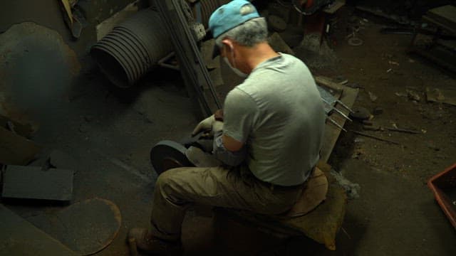 Worker sharpening a knife in a workshop