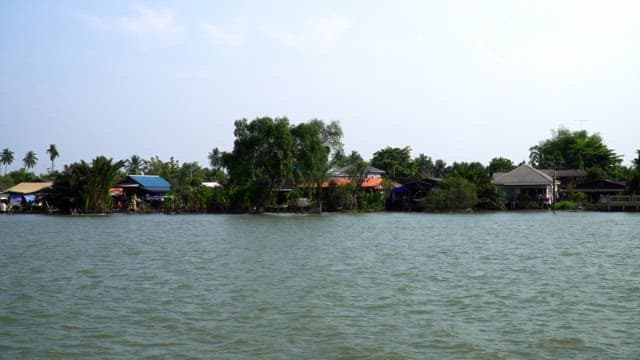 화창한 날 보트가 지나다니는 강변 마을