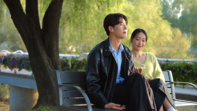 Couple enjoying music on a park bench