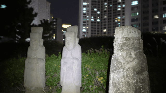 Traditional stone statues in park at night