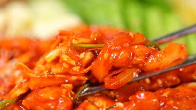 참깨가 뿌려진 매콤새콤한 한치 무침 한 젓가락