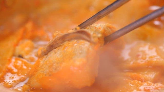 Fish lifted with chopsticks from boiling codfish soup