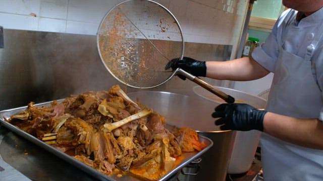 Steamed meat pieces on a metal tray in a kitchen