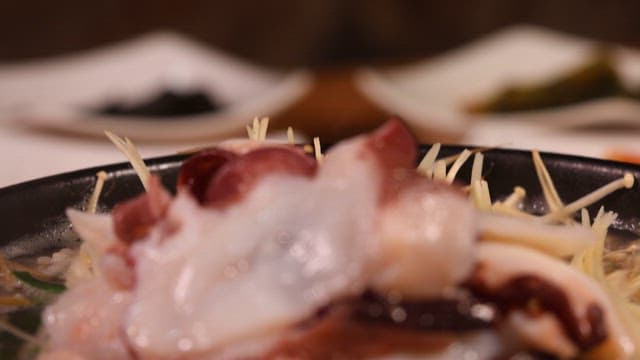 뜨거운 돌솥에 제공된 문어 콩나물국밥