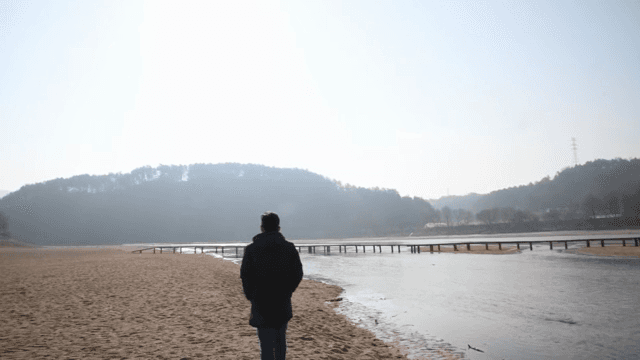 홀로 모래사장 위를 걷는 남성