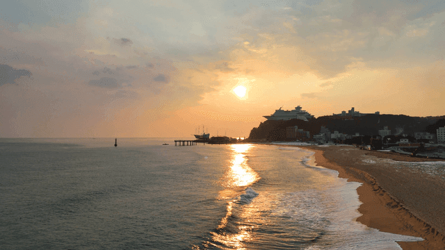 Calm beach with waves at sunset
