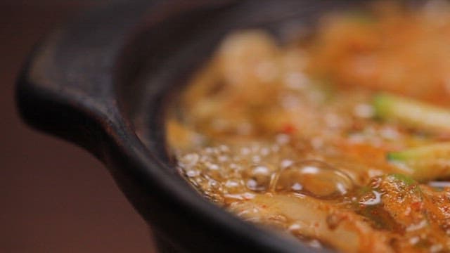 Spicy noodle soup boiling in a pot