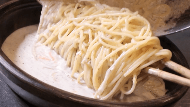 Creamy pasta being served in a bowl