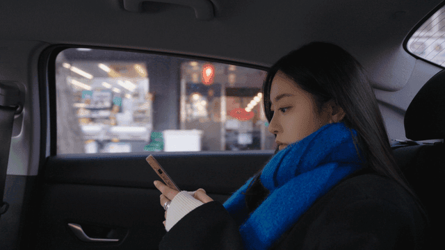 Woman using her smartphone in a taxi