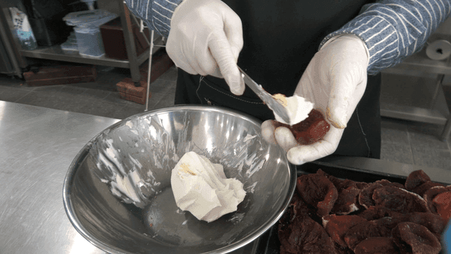 Cream cheese being spread on dried persimmons