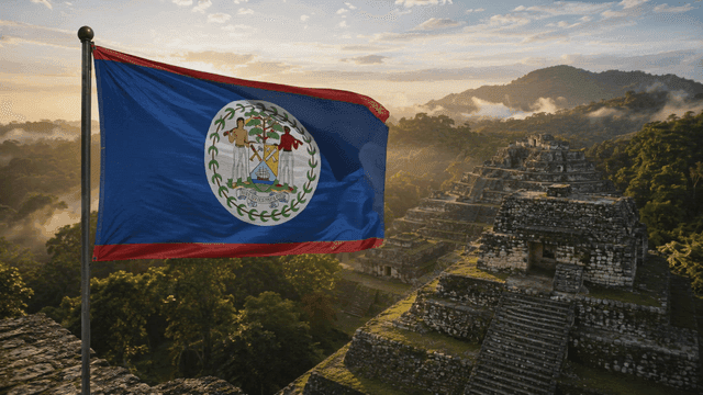 Belizean flag fluttering at sunrise near ancient ruins