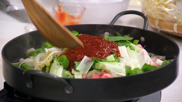 철판에서 나무 주걱으로 요리되는 콩나물 불고기