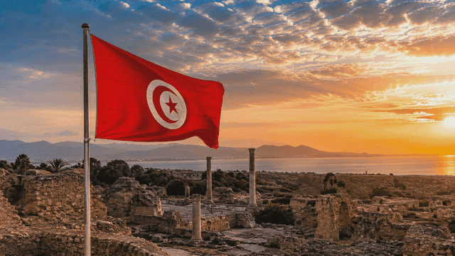 Historic site with Tunisian flag at sunset