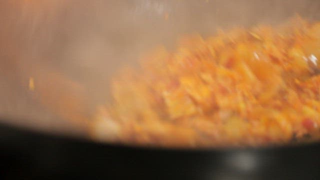 Stir-frying minced meat and onions in a hot wok