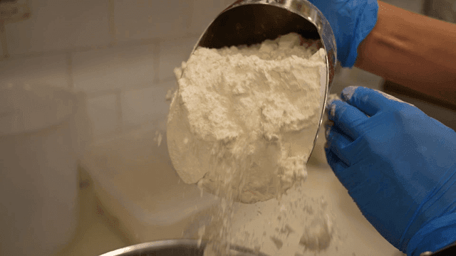 Baker pouring flour