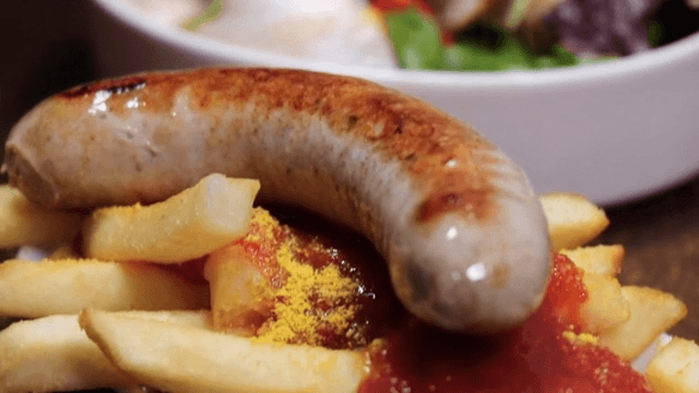 감자튀김과 소시지에 카레 가루 뿌리기