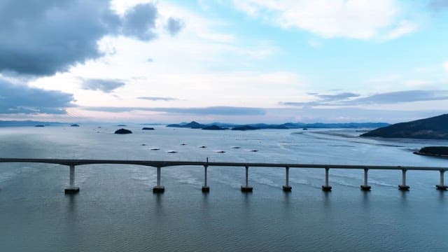 Long bridge over a calm sea with islands