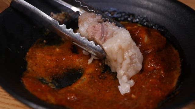 돼지수육에 소스를 찍는 장면