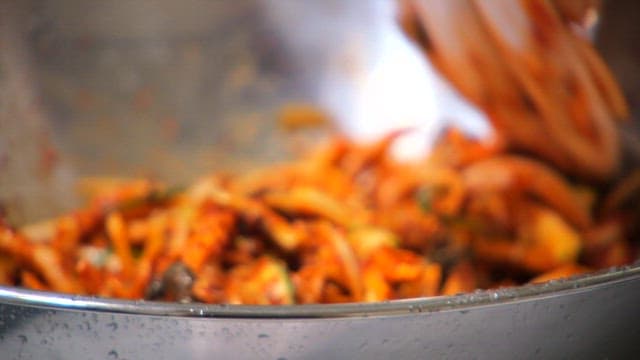 매운 양념으로 느타리버섯과 채소를 섞는 모습