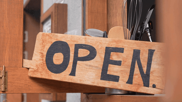 Wooden open sign hanging on cafe door