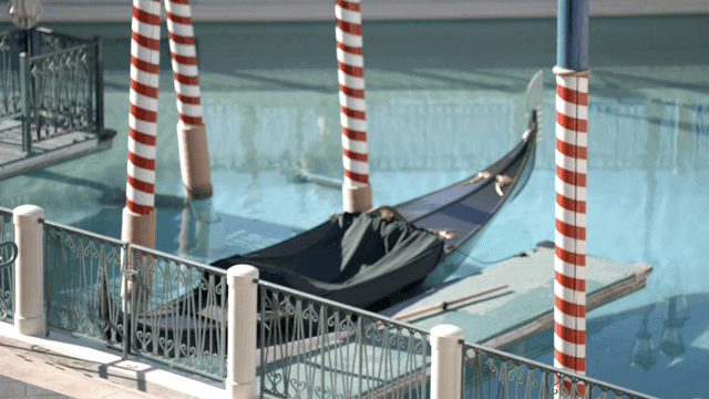 줄무늬 기둥이 있는 운하에 정박한 곤돌라