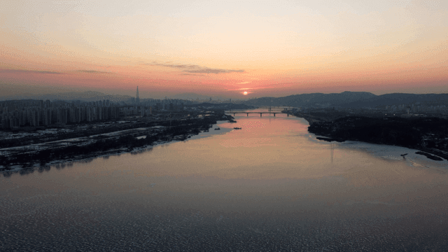 Sunset over a river with city skyline
