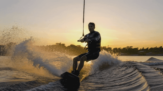 Wakeboarding at sunset on a calm lake