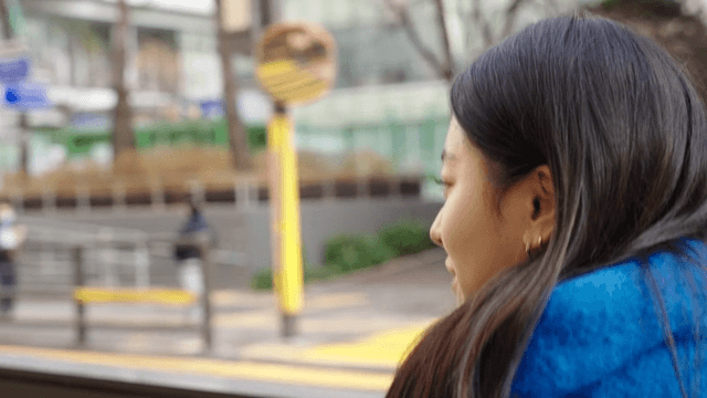 Profile of a woman wearing a scarf walking down the street