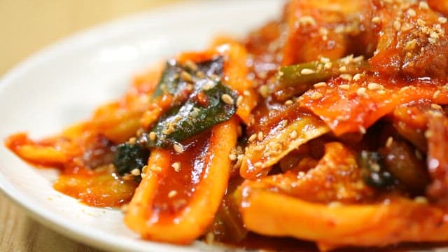 Spicy stir-fried squid and pork with sesame seeds served on a plate