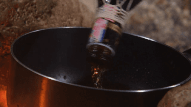 불 위에 있는 냄비에 액체를 붓는 장면