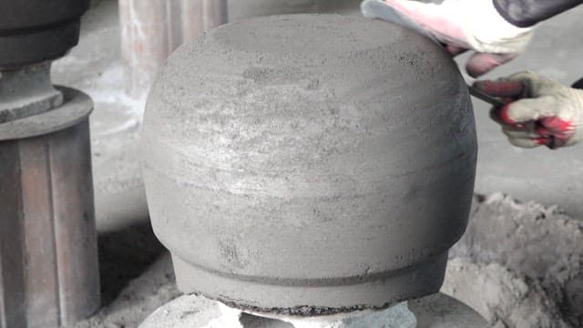 장갑을 끼고 무쇠 가마솥 표면을 다듬는 모습