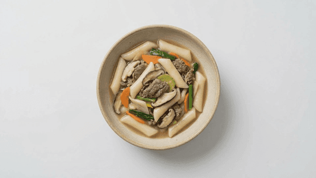 Royal Tteokbokki stir-fried with beef, shiitake mushrooms, carrots, and zucchini in soy sauce seasoning