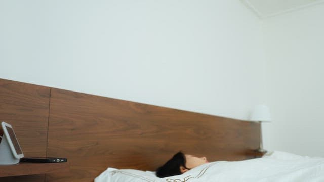 Young Adult Woman Checking Phone in Bed