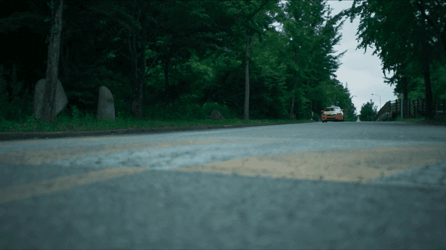 숲길을 달려오는 주황색 택시