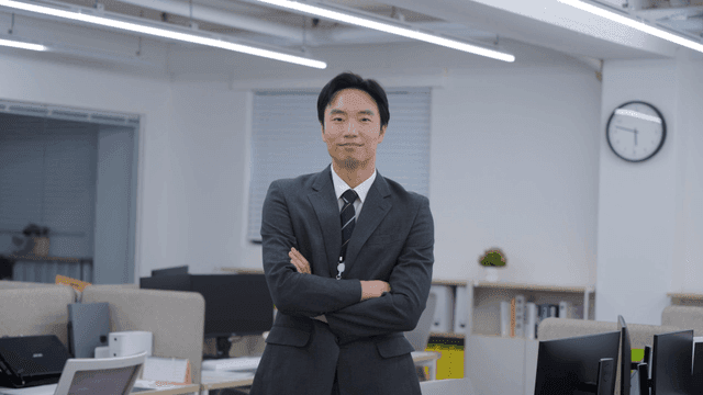 An office worker smiling with arms crossed in the office