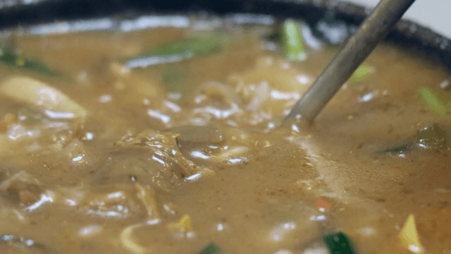 Sundae soup in a hot pot stirred with a spoon