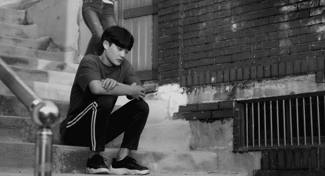 계단에 앉아 생각에 잠긴 남성을 놀리는 여성