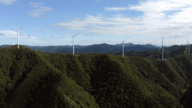 Wind turbines on lush green mountains