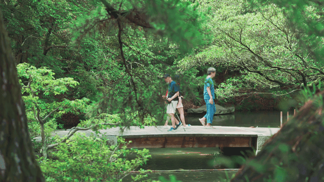 호수의 좁은 나무 다리를 건너는 사람들