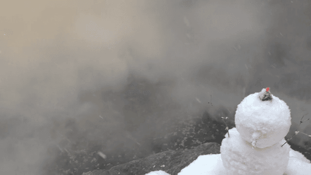 Snow-covered hot spring with steam rising