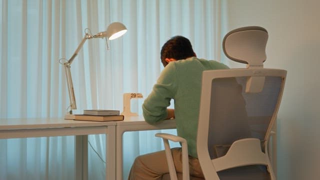 Man sitting at a desk in a calmly lit room