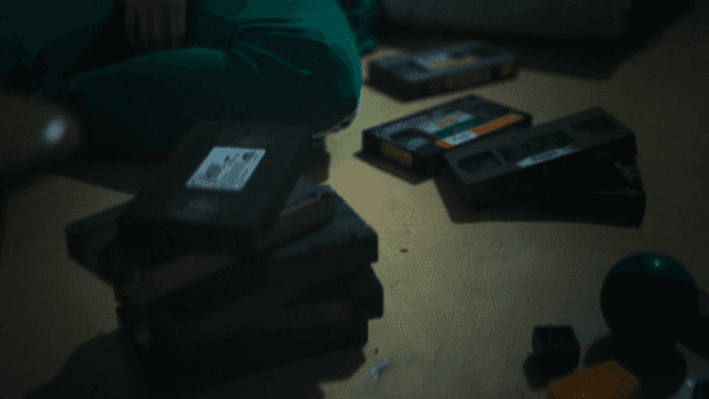 Person sitting on floor with videotape