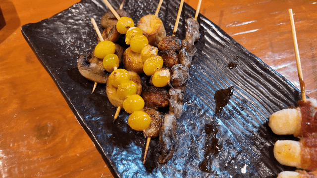 Assorted skewers on black plate