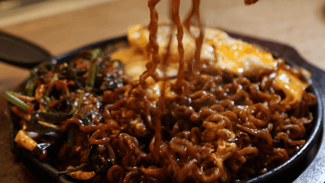 Jjajang Ramen topped with green onion kimchi and cheese